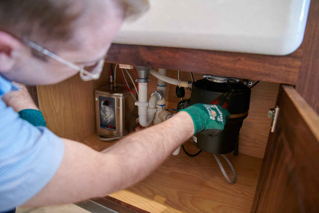 plumber working on garbage disposal