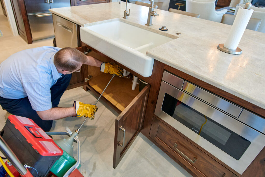 plumber repairing kitchen sink plumbing