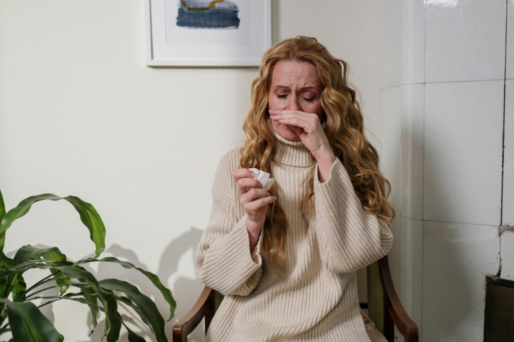 woman covering her nose when sneezing