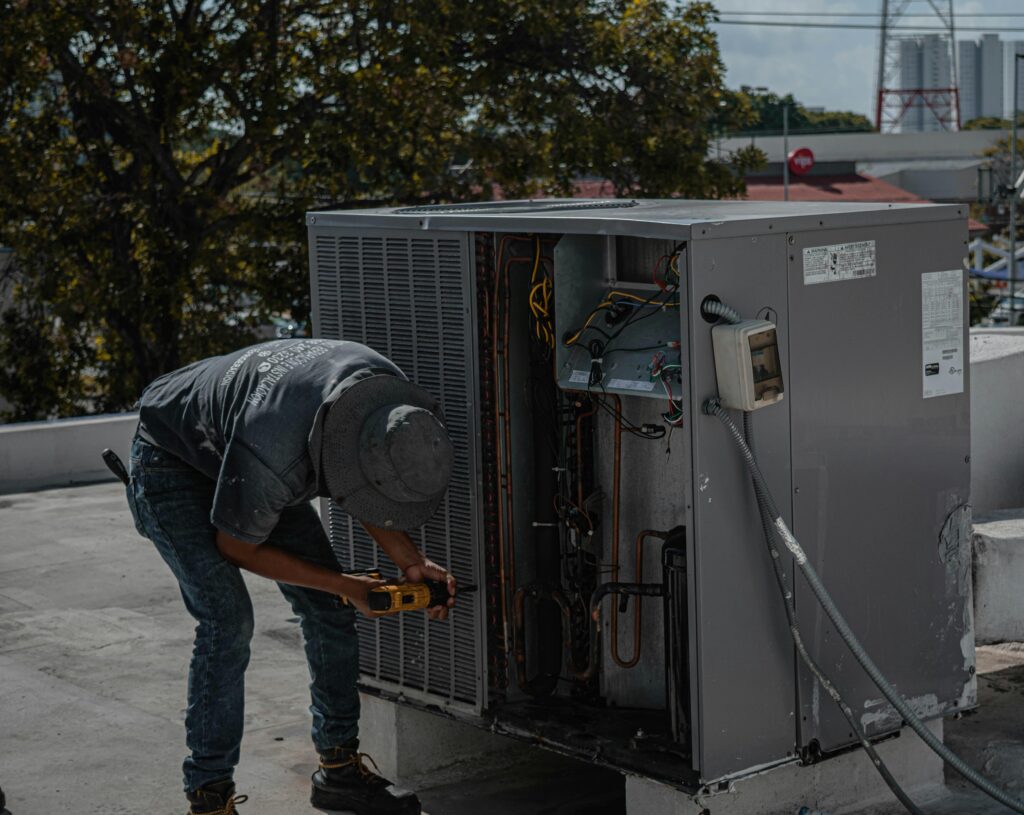 electrician working on rooftop AC unit