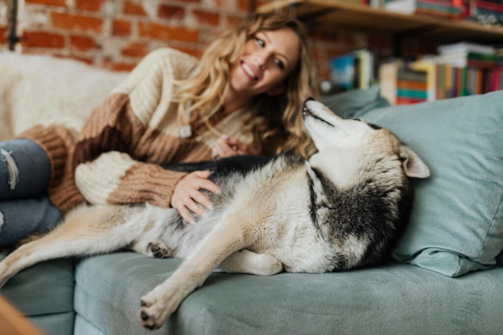 woman with husky on couch