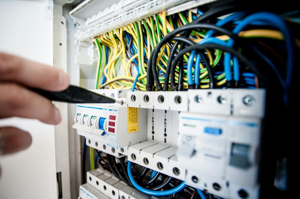 electrician working on electrical panel in home